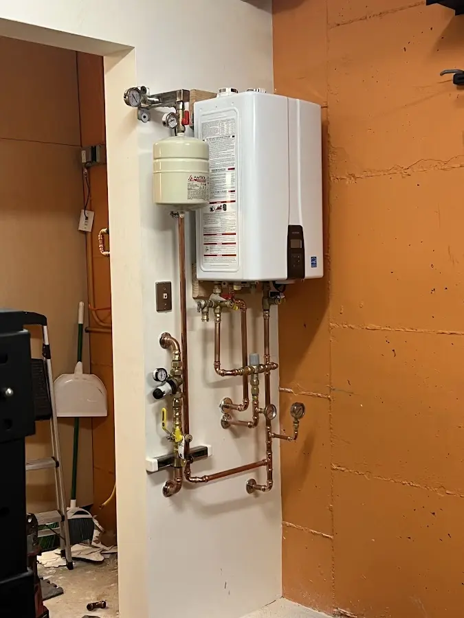 Plumbing technician inspecting water heater connections in Kendall West